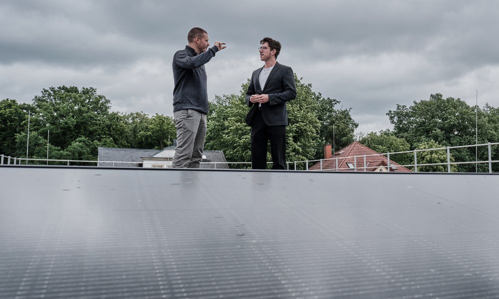Projektkoordinator Patrick Emmerlich (links) im Gespräch mit dem Energiemanager Marian Hanke. Im Vordergrund: eine neu installierte Photovoltaik-Anlage. Bild: Bertram Solcher